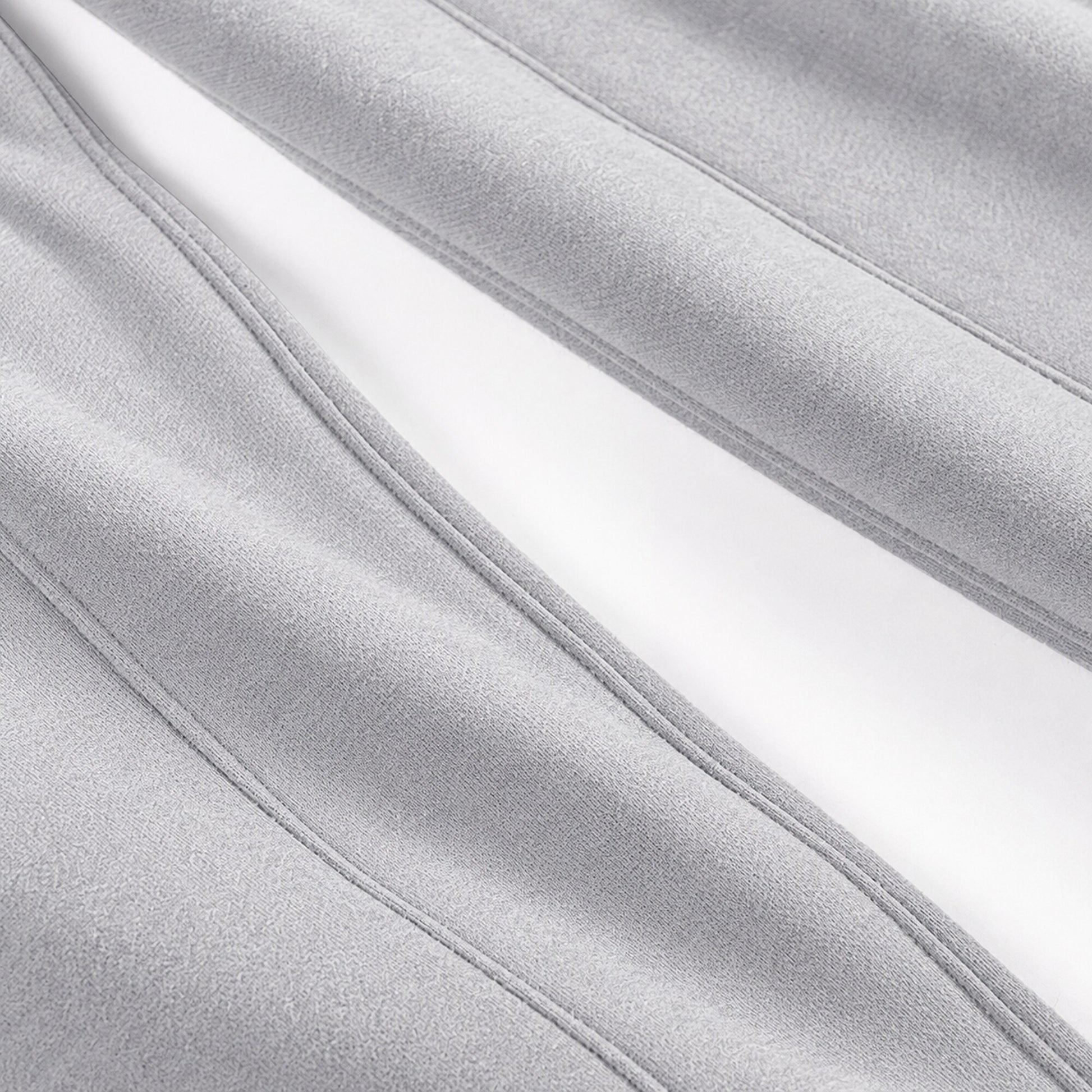 Close-up of the long stitched seam construction on light grey FineAF Magnetic pants
