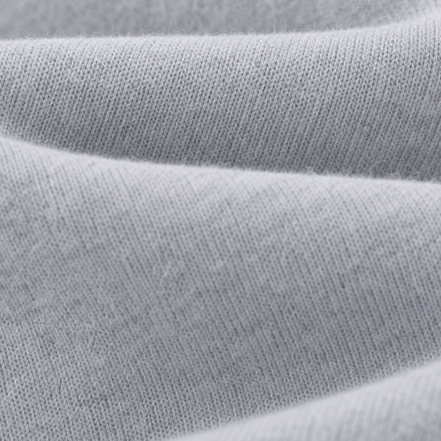 Macro view of the soft light grey knit surface of FineAF Magnetic pants