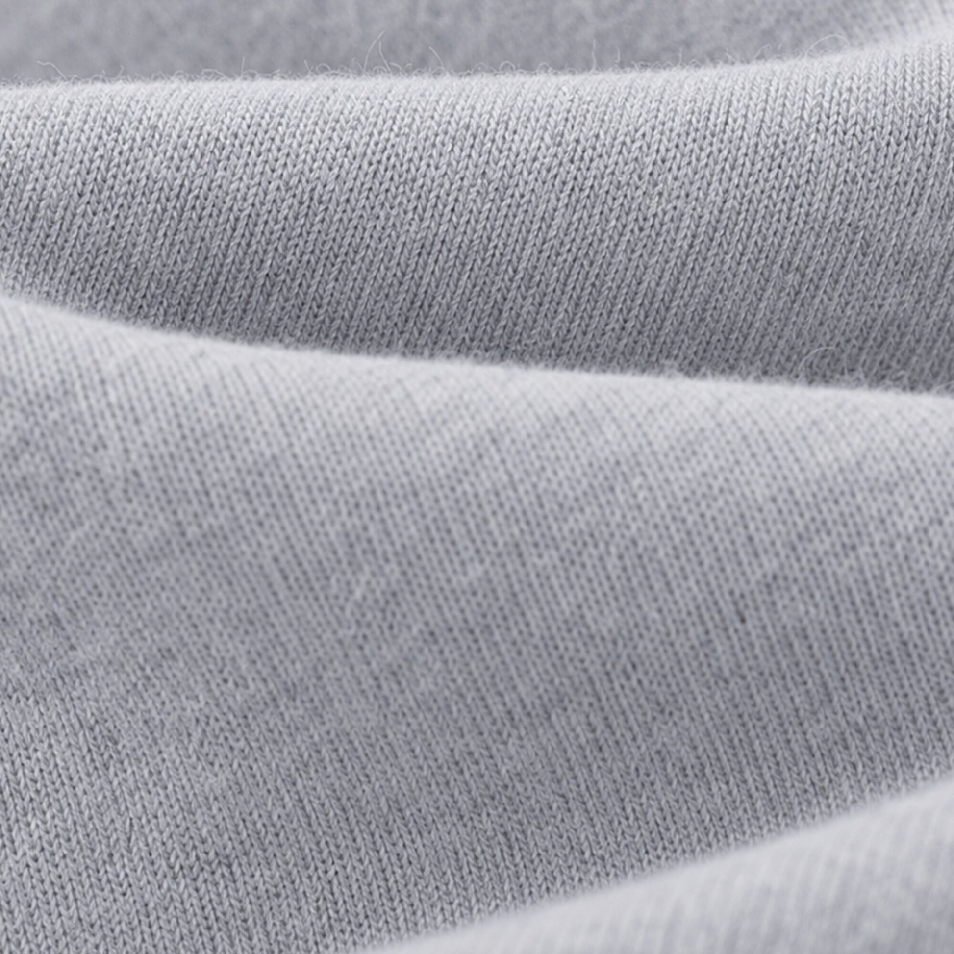 Macro view of the soft light grey knit surface of FineAF Magnetic pants