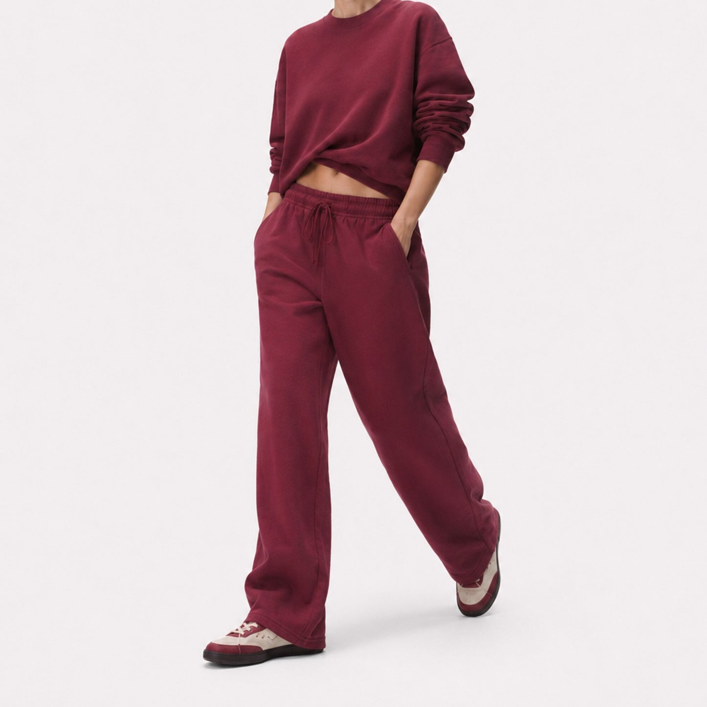 Walking view of oversized FineAF Visionary wine pants showing relaxed hip volume and long straight-leg drape.