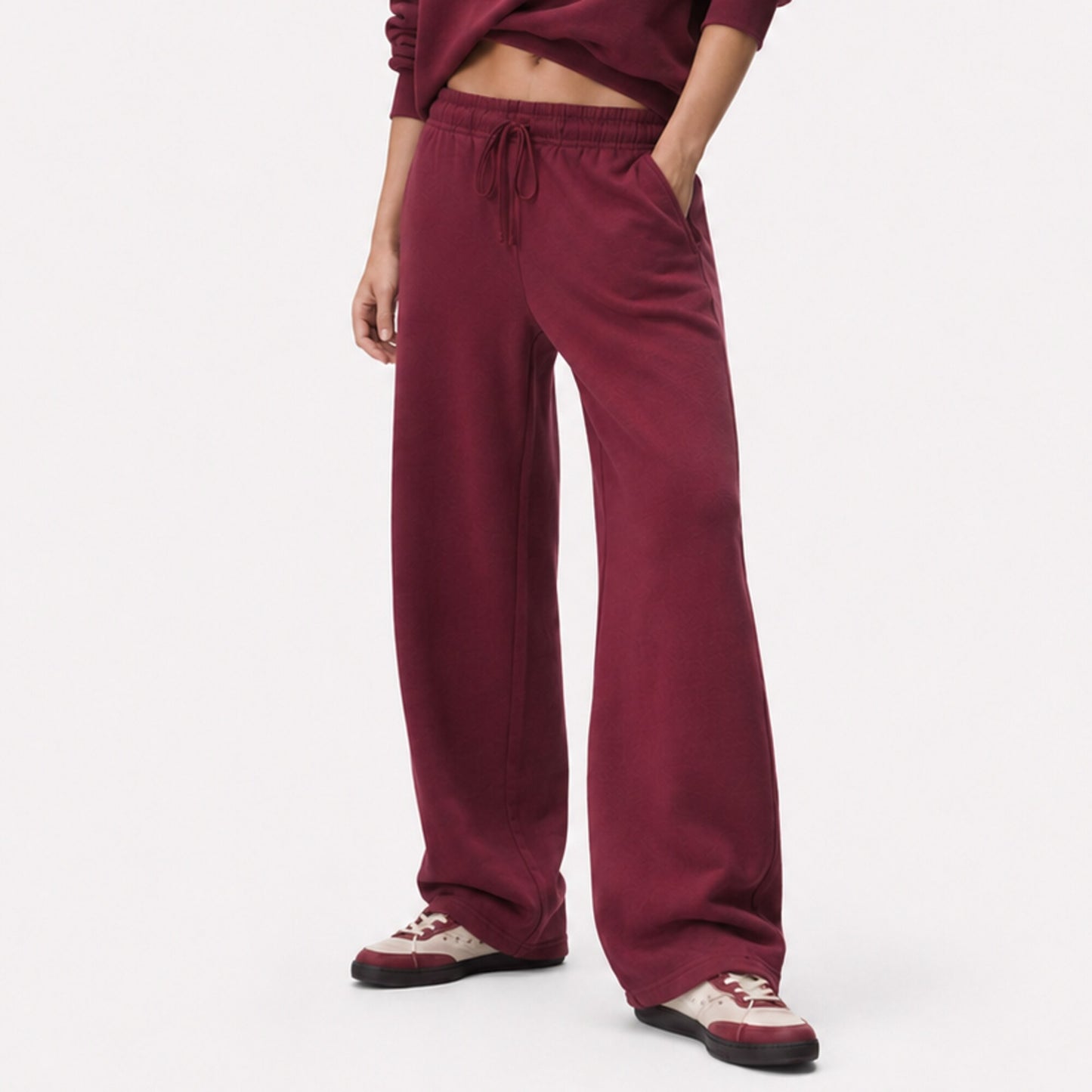 Close fit view of FineAF Visionary wine pants from the drawstring waistband to the open hems and sneakers.