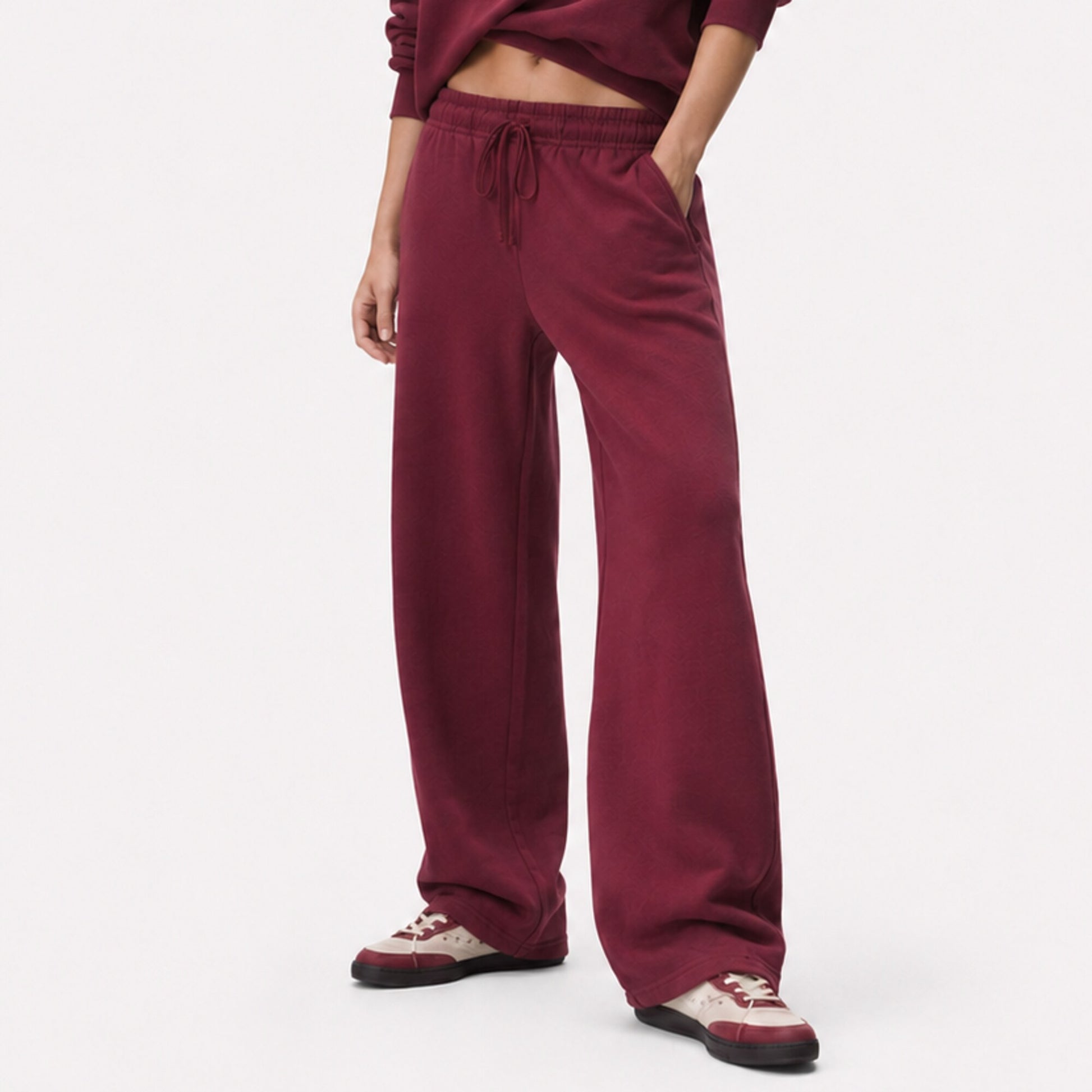 Close fit view of FineAF Visionary wine pants from the drawstring waistband to the open hems and sneakers.