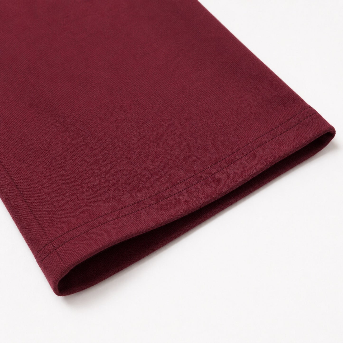 Close-up of the FineAF Visionary wine pant open hem and parallel topstitching.