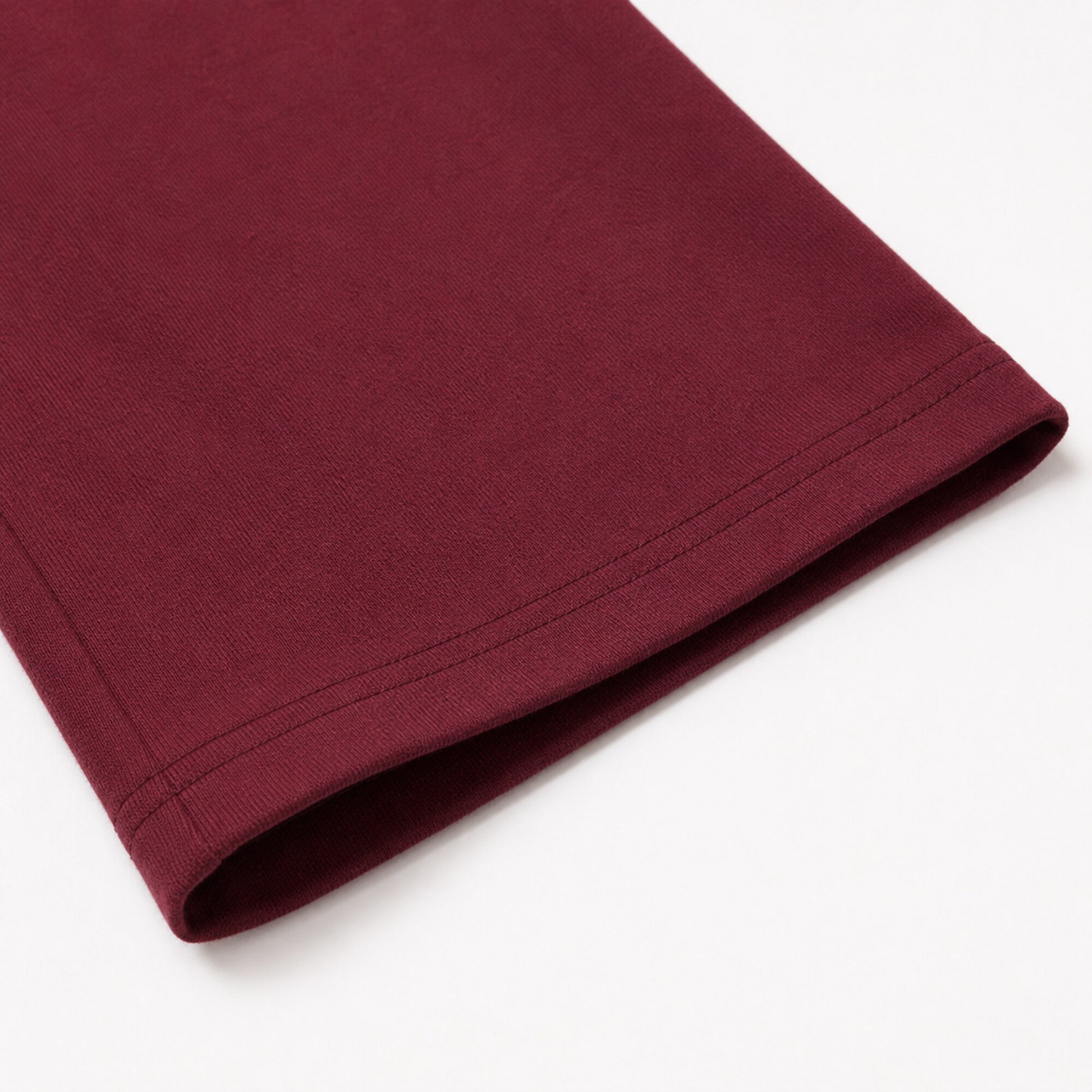 Close-up of the FineAF Visionary wine pant open hem and parallel topstitching.