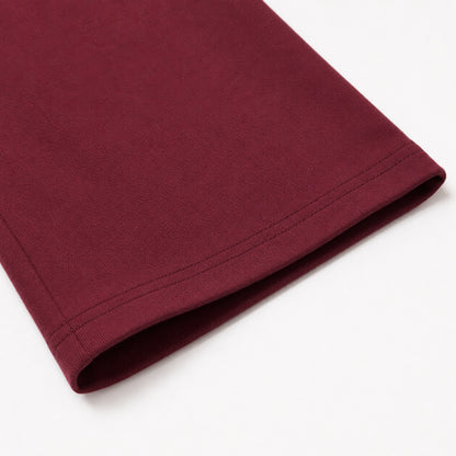 Close-up of the FineAF Visionary wine pant open hem and parallel topstitching.