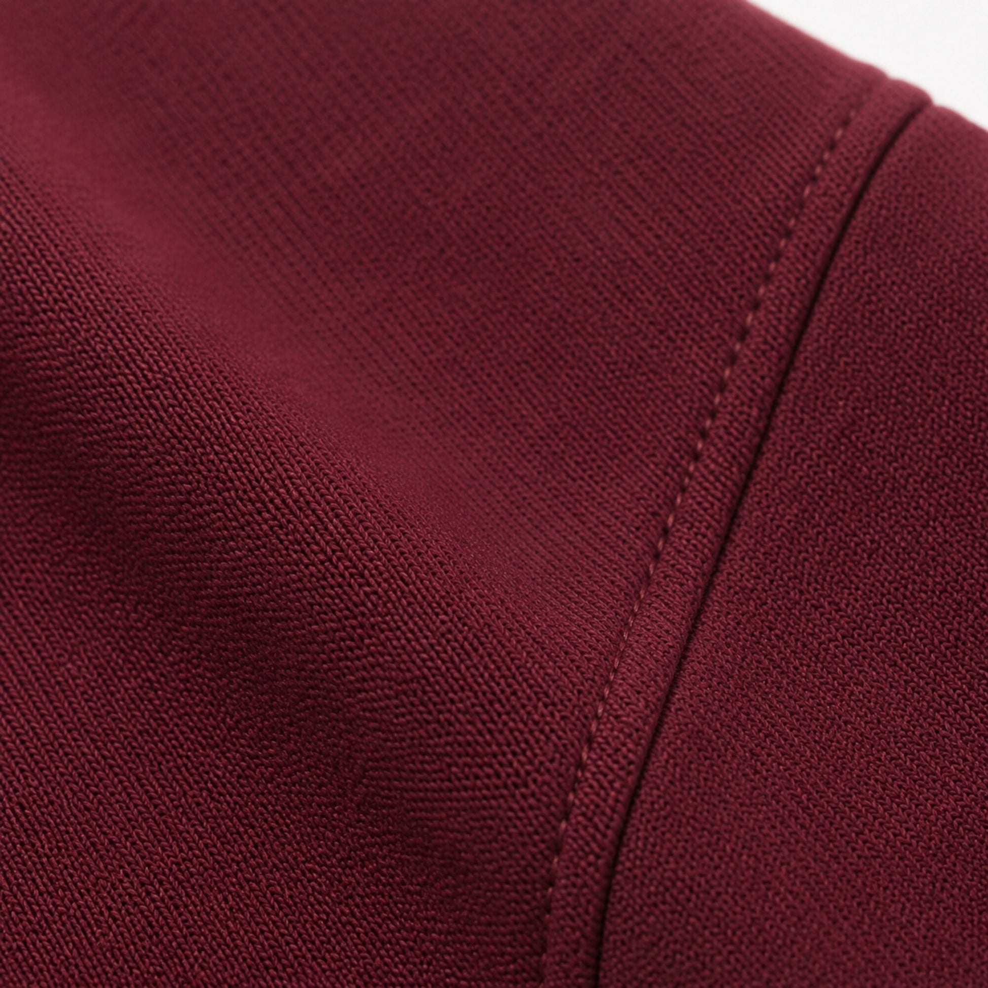 Macro of the FineAF Visionary wine pant matte knit fabric and straight construction seam.