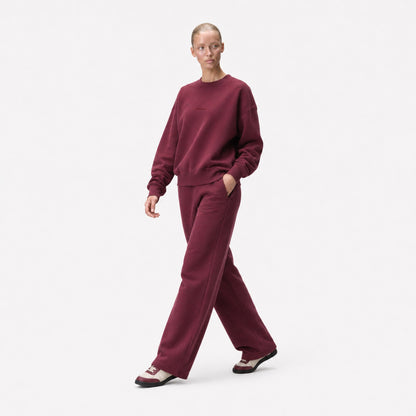 Three-quarter editorial view of the FineAF Visionary wine sweatshirt and matching sweatpants