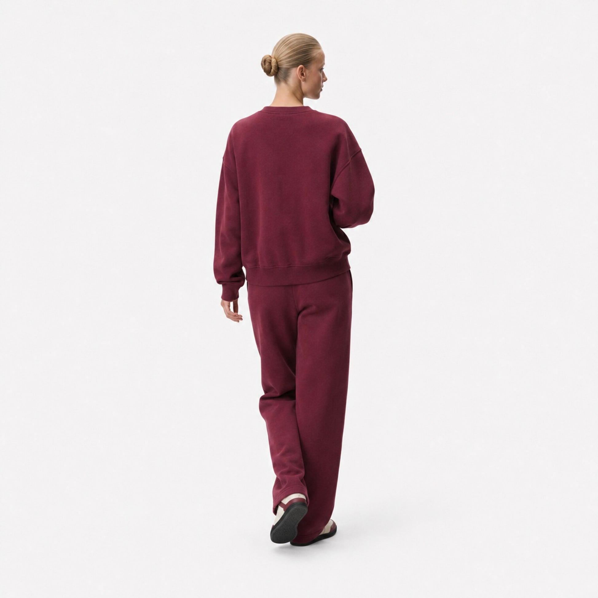 Back view of a woman wearing the FineAF Visionary wine sweatshirt and matching straight-leg sweatpants