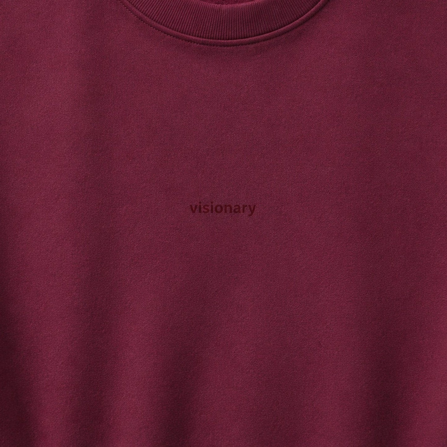 Close-up of the small tonal visionary chest design on wine fleece