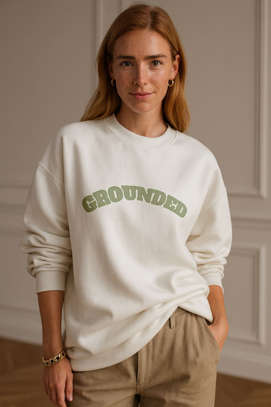 Model wearing FineAF GROUNDED Sweatshirt in bright white organic cotton, relaxed fit, natural daylight studio.